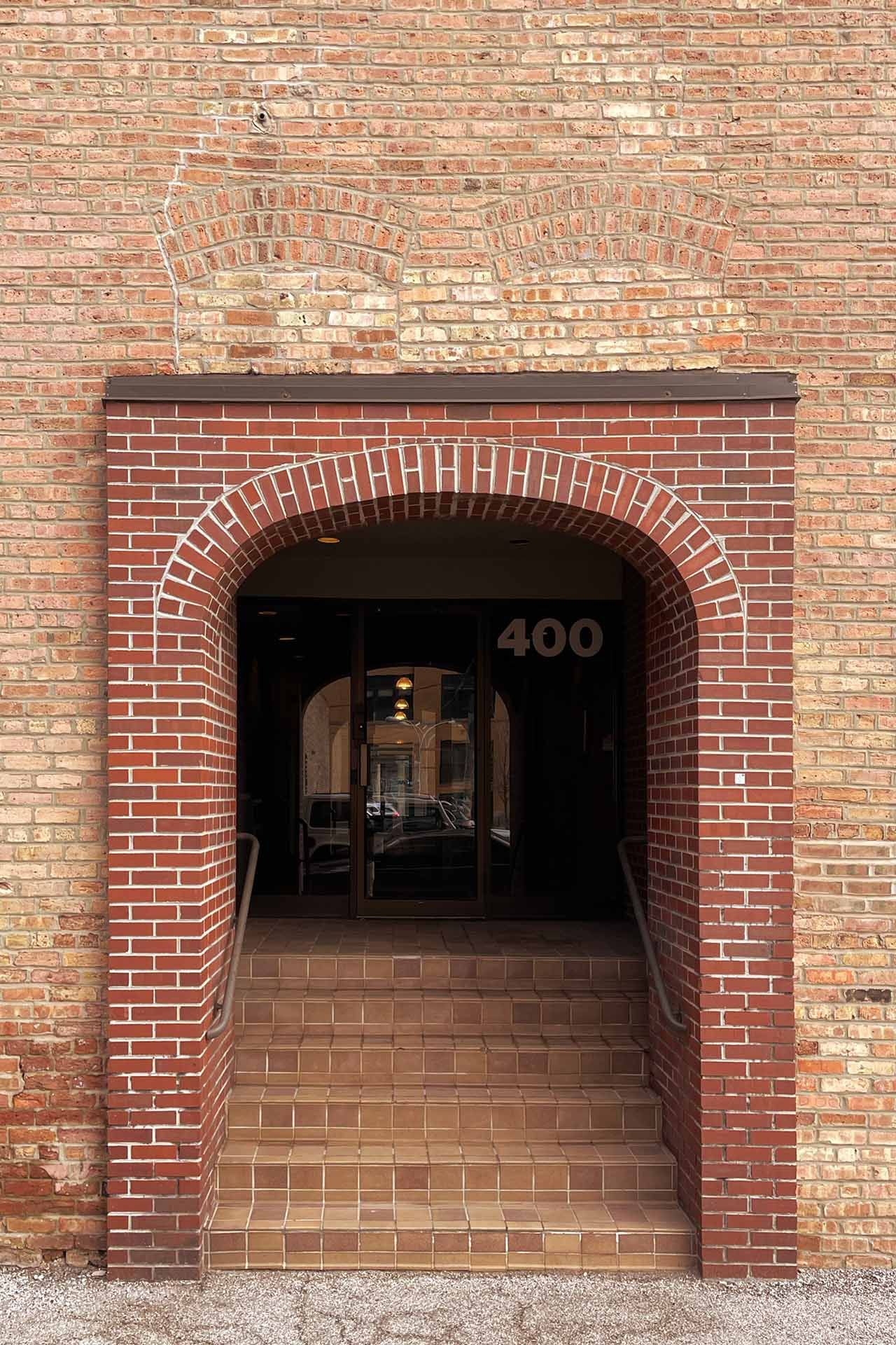 An entryway arch cutting through two previously bricked in windows