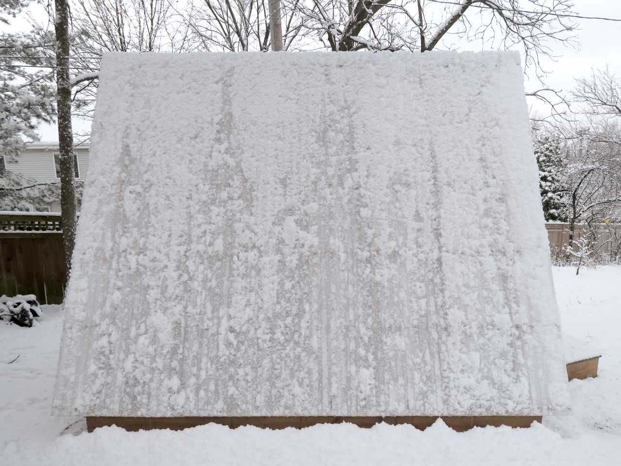 Snow clings to the corrugated roof, with patches of snow which have fallen off from their own weight, forming interesting patterns