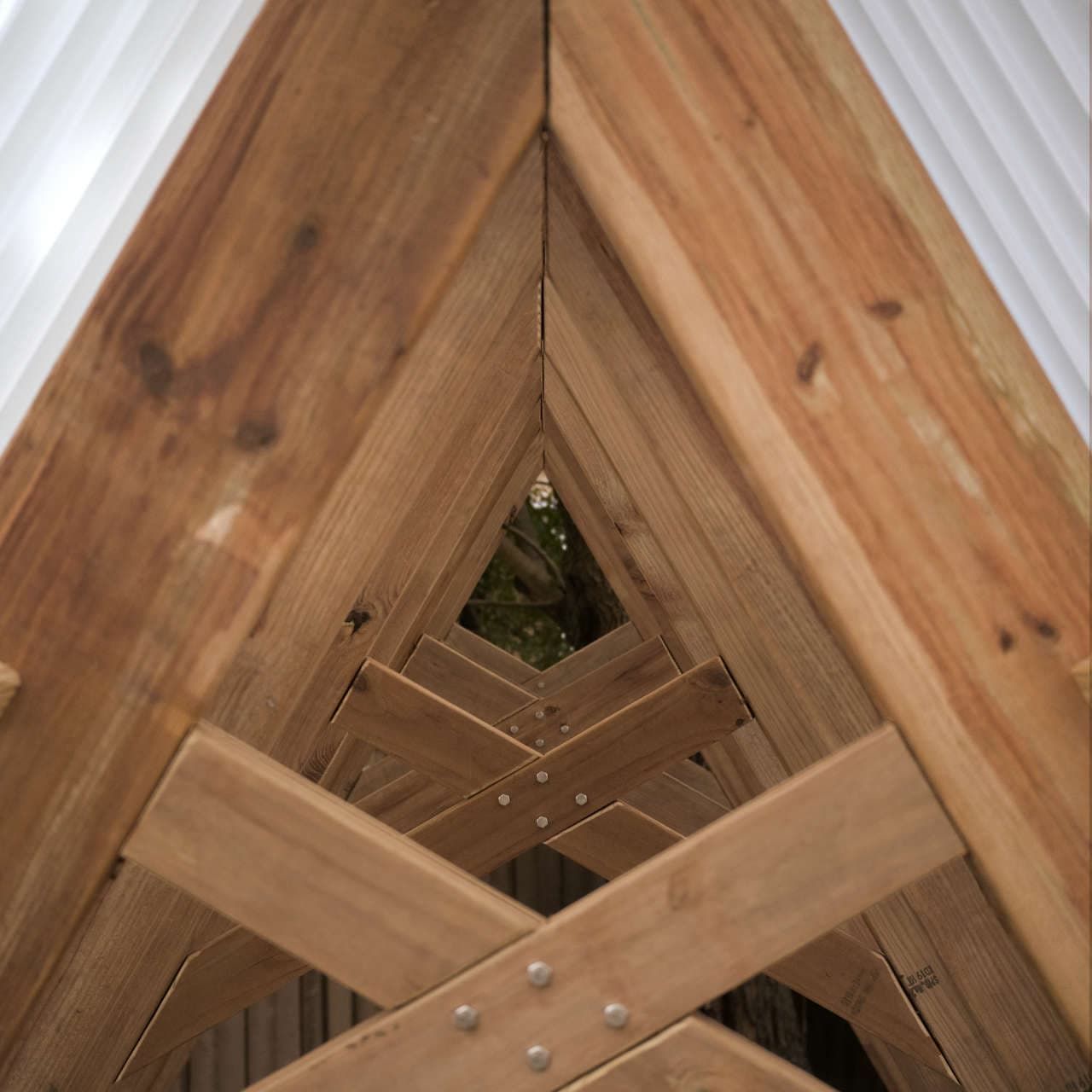 A view through the space between the rafters and collar ties, from one end of the structure to the other