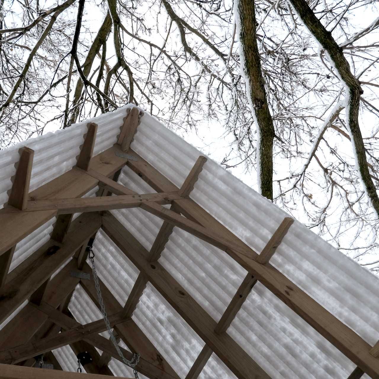 The roof hangs overhead, with tree branches whose leaves have been lost for the winter hanging further overhead