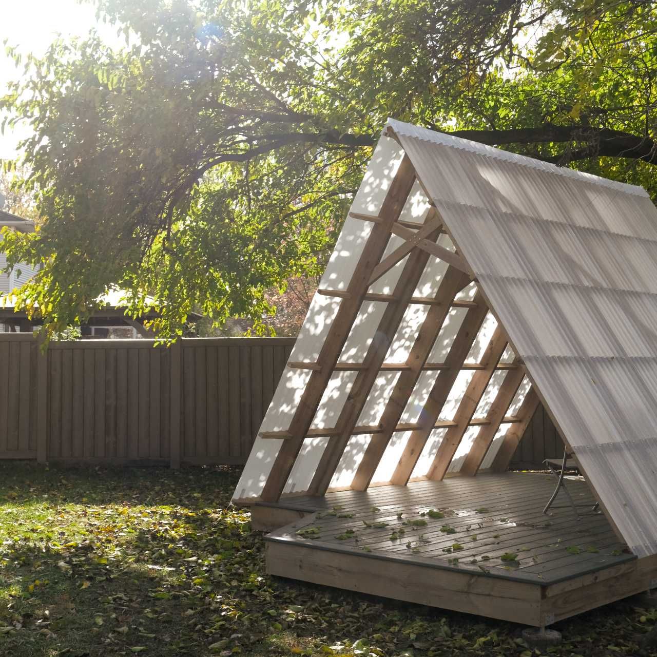 An overhead tree casts a summer-time shadow across the corrugated roof